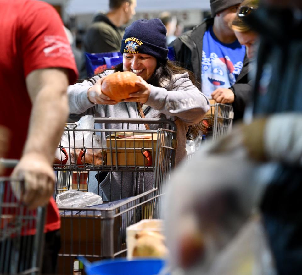 U.S. Navy veteran Lidia Cleary, 43, of Ayer gets a pumpkin while in line during Veterans Inc.'s annual Holiday Harvest Tuesday.