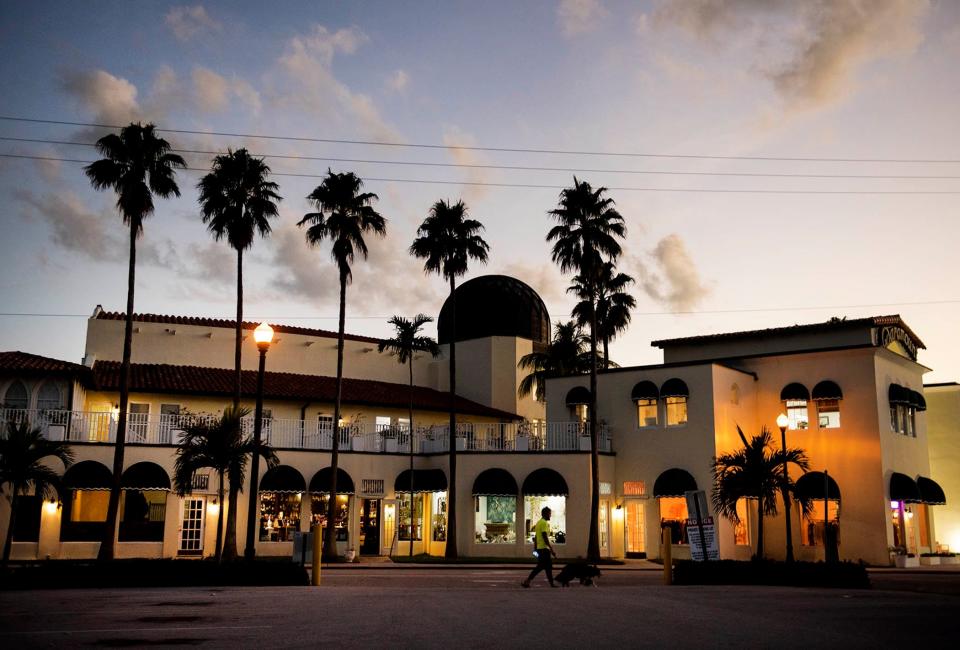 A man walks a dog along Sunrise Avenue in Palm Beach.