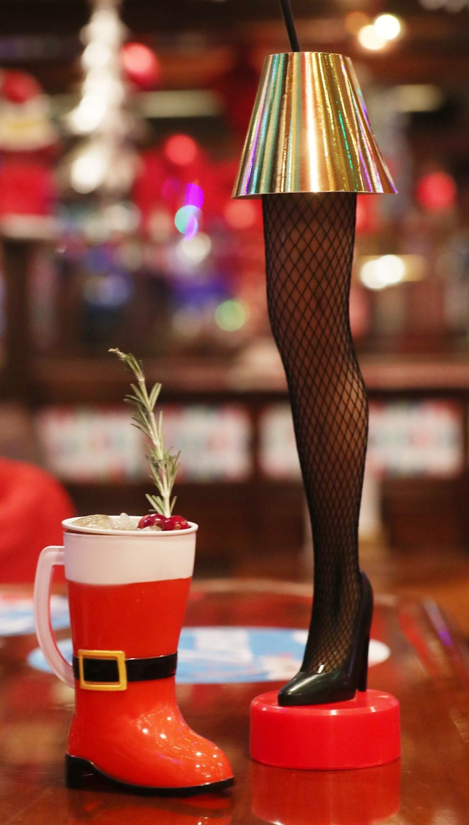 Santa's Boot Warmer, left, is made with Western Reserve Distillery Gin, cold-pressed pear juice, fresh rosemary and cranberries, served in a Santa boot mug. Chocolate Candy Cane, with Tito's handmade vodka, peppermint liqueur, chocolate liqueur and vanilla cream, is shown  served in a 20-inch "Fragile (FRA-GEE-LAY) It's a Major Award!" leg lamp glass at Blitzen's in Hudson.