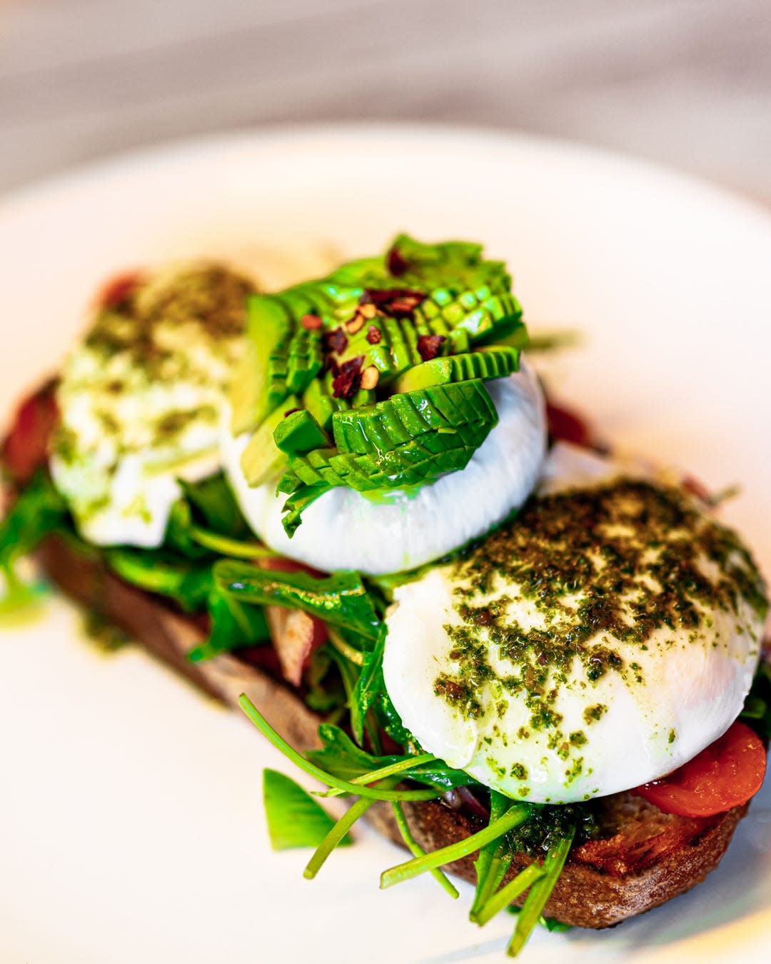 Sourdough with poached eggs, avocado, tomatoes, arugula and burrata at Over Easy Kitchen.