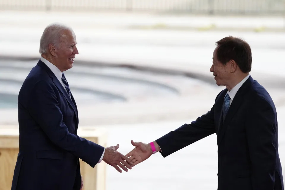 President Joe Biden, left, shakes hands with Taiwan Semiconductor Manufacturing Company Chairman Mark Liu, right, as the two meet on stage after touring the TSMC facility under construction in Phoenix, Tuesday, Dec. 6, 2022. (AP Photo/Ross D. Franklin)