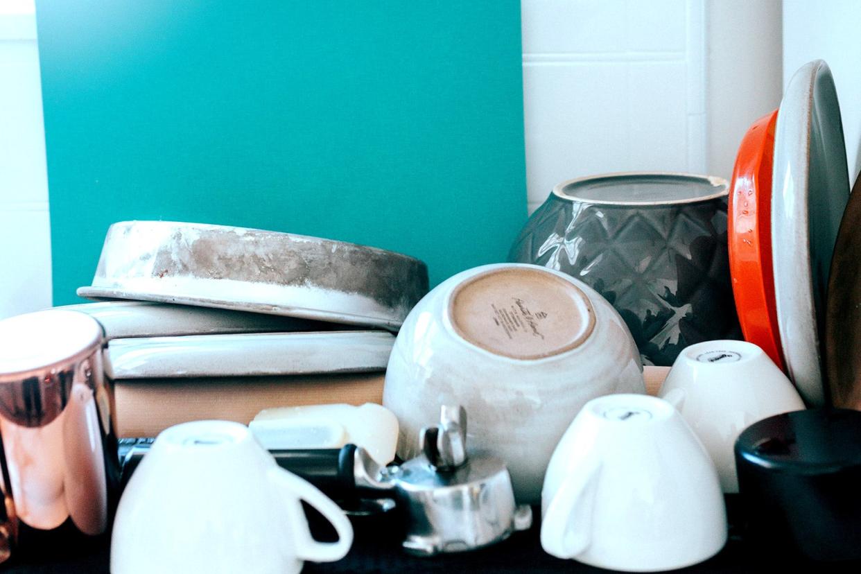 A stress-inducing pile of dishes covers the kitchen counter.