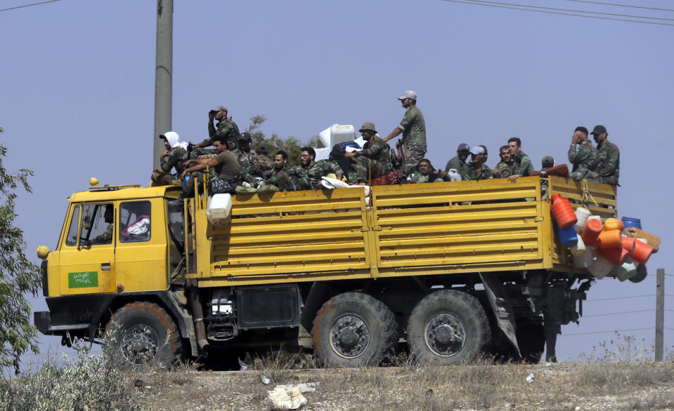 Syrian army soldiers loaded aboard a truck near village of Sh.Miskin, Syria, Tuesday, Aug. 14, 2018. The Russian military said Tuesday that its forces in Syria will help U.N. peacekeepers fully restore patrols along the frontier with the Israeli-occupied Golan Heights, reflecting Moscow's deepening role in mediating between the decades-old foes. (AP Photo/Sergei Grits)