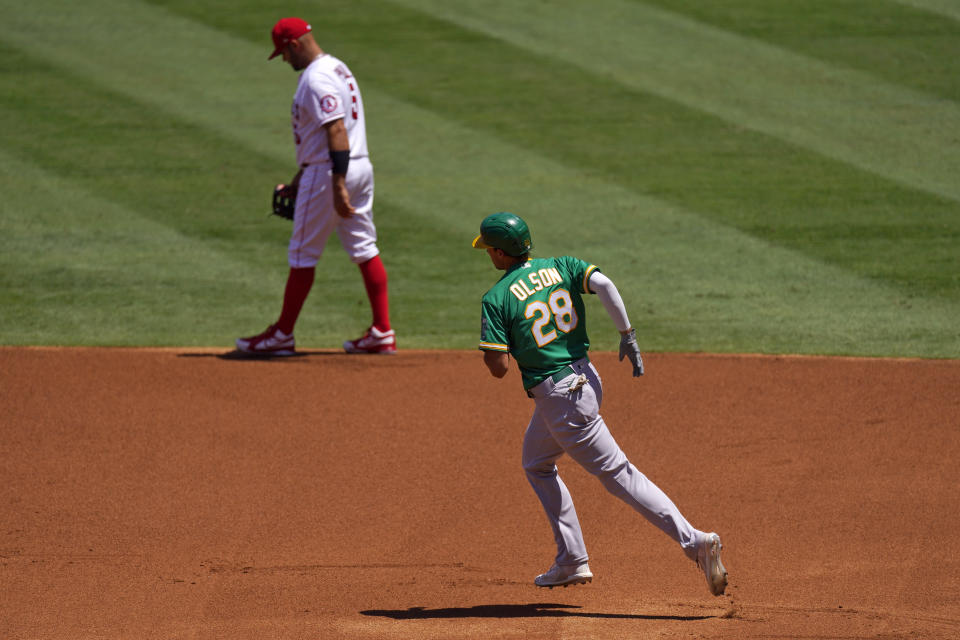 Oakland Athletics' Matt Olson, right, passes Los Angeles Angels first baseman Albert Pujols as he rounds first after hitting a solo home run during the first inning of a baseball game Wednesday, Aug. 12, 2020, in Anaheim, Calif. (AP Photo/Mark J. Terrill)