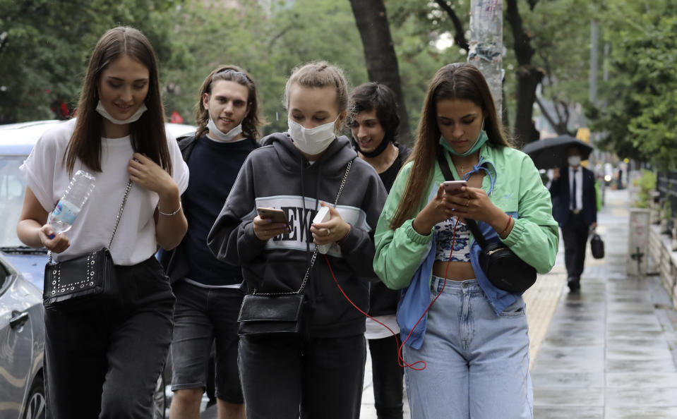 People walk in a popular street, in Ankara, Turkey, Wednesday, June 17, 2020. Turkey has made the wearing of face masks mandatory in five more provinces, following an uptick in COVID-19 cases. Health Minister Fahrettin Koca tweeted Tuesday that the wearing of masks is now compulsory in 42 of Turkey's 81 provinces.(AP Photo/Burhan Ozbilici)