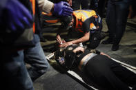 A wounded Palestinian demonstrator receives treatment after he was hit during clashes with Israeli police at Damascus Gate just outside Jerusalem's Old City, Thursday, April. 22, 2021. Palestinians clashed with Israeli police over restrictions on Ramadan gatherings ahead of a planned march by Lahava, a Jewish extremist group, to the area later on Thursday amid heightened tensions in the city. (AP Photo/Ariel Schalit)