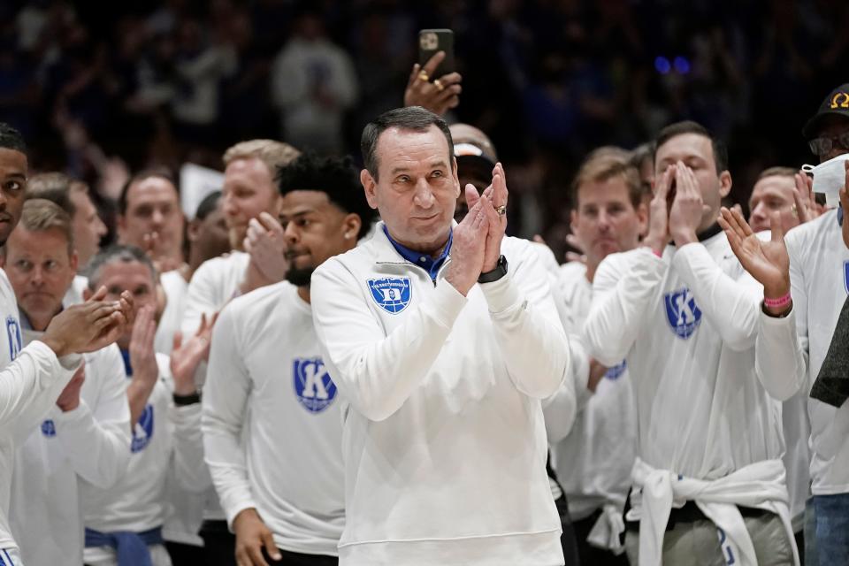 Surrounded by former players, Duke coach Mike Krzyzewski applauds while being recognized prior to the team's NCAA college basketball game against North Carolina in Durham, N.C., Saturday, March 5, 2022. The matchup is Krzyzewski's final game at Cameron Indoor Stadium.