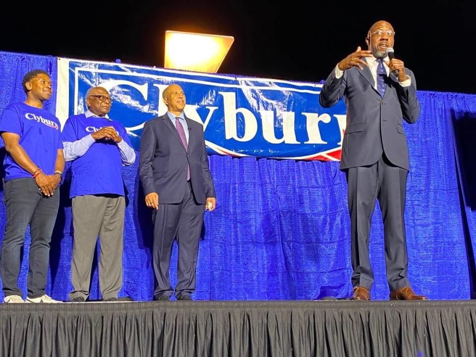 El senador estadounidense Raphael Warnock, demócrata por Georgia, habla en el Jim Clyburn 2024 Fish Fry mientras el estratega político Antjuan Seawright, Clyburn y el senador estadounidense Cory Booker, demócrata por Nueva Jersey, escuchan el viernes 17 de mayo de 2024.