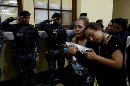 Relatives of a slain policeman react during a homage for their loved one and two colleagues, who were killed during an attack, at the headquarters of the Civil National Police (PNC) in Guatemala City, Guatemala, March 21, 2017. REUTERS/Luis Echeverria