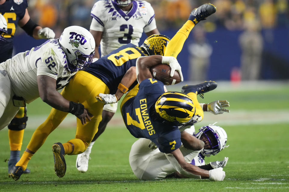 Michigan running back Donovan Edwards (7) is up-ended against TCU during the second half of the Fiesta Bowl NCAA college football semifinal playoff game, Saturday, Dec. 31, 2022, in Glendale, Ariz. (AP Photo/Ross D. Franklin)