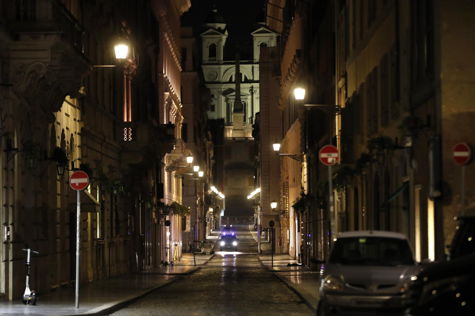 An Italian Carabinieri paramilitary police car patrols an empty street leading to the Spanish Steps and Trinita' dei Monti Church Rome, early Monday, Oct. 26, 2020. Since midnight last Friday and for the next 30 days, people in Lazio are not allowed to leave their homes from midnight to 5 a.m. daily, except to go to or return from work or for other urgent reasons such as health issues. (AP Photo/Alessandra Tarantino)