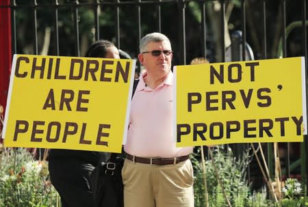 A protester holds up signs outside the courthouse ahead of a bail hearing in U.S. financier Jeffrey Epstein's sex trafficking case in New York City