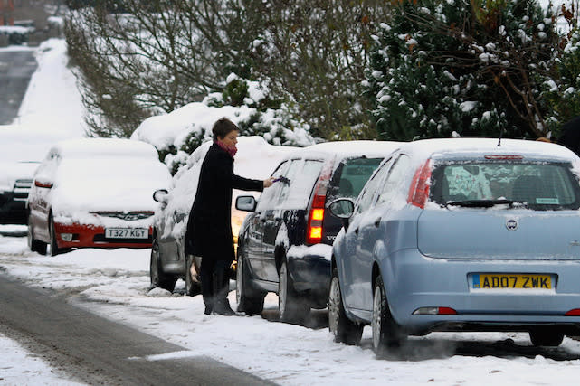A member of the public de-ices their car near Ashford, Kent, as large areas of Britain were brought to a halt today as the big freeze tightened its grip on the nation.