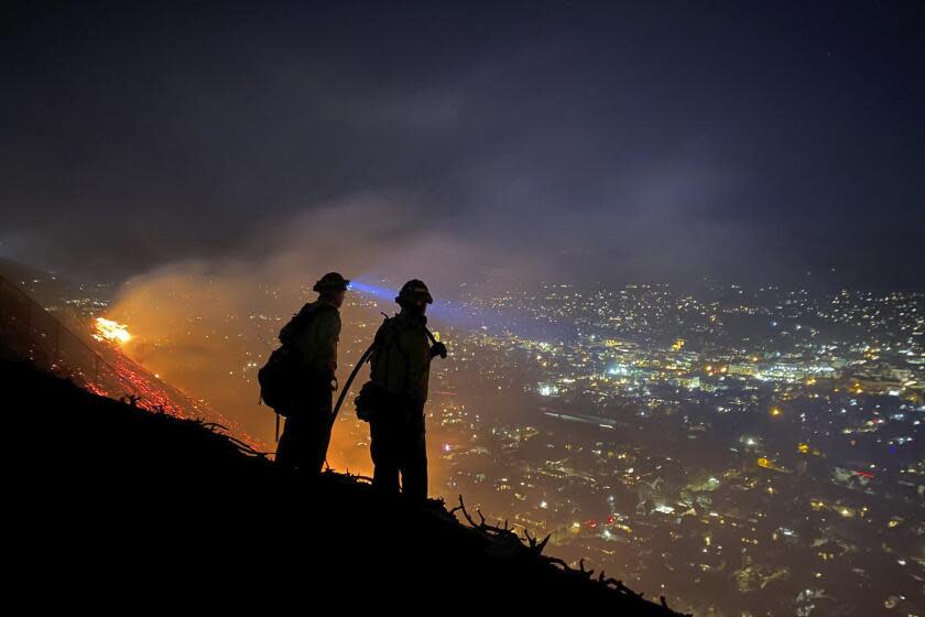 In this photo provided by the Santa Barbara County Fire Department, firefighters battle a brushfire in Santa Barbara, Calif., on Thursday, May 20, 2021. Hard work by firefighters and a decrease in winds stopped the spread of the brushfire that triggered evacuations authorities said Friday. (Santa Barbara County Fire Department via AP)