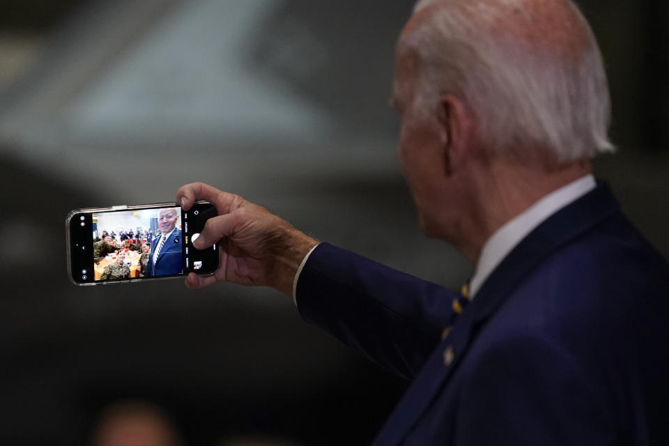 FILE - President Joe Biden takes a selfie at Marine Corps Air Station Cherry Point in Havelock, N.C., Monday, Nov. 21, 2022, at a Thanksgiving dinner with members of the military and their families. Democrats are wrestling with how to deploy generative AI. Still smarting from being outmaneuvered on social media by Donald Trump and his allies in 2016, Democratic strategists say they are nevertheless treading carefully in embracing artificial intelligence tool that disinformation experts say could pose a threat to democracy. (AP Photo/Patrick Semansky, File)