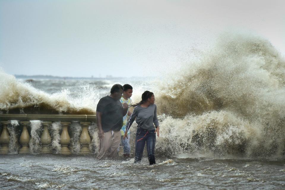 Riverside resident Saraya Harris, 12, her brother Joshua Harris, 10, and Alfred Lester watch as a wave slams into the seawall and balustrades of Riverside's Memorial Park as Northeast Florida felt the effects of Hurricane Idalia on Aug. 30.
