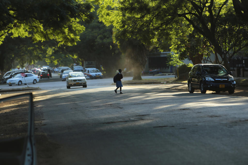 A young girl crosses the streets in Harare, Zimbabwe, Thursday, March, 19, 2020. More African countries have closed their borders as the coronavirus’ local spread threatens to turn the continent of 1.3 billion people into an alarming new front for the pandemic. For most people the new coronavirus causes only mild or moderate symptons.For some it can cause more severe illness, especially in older adults and pepole with existing health problems. (AP Photo/Tsvangirayi Mukwazhi)