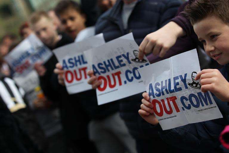 Newcastle fans boycotting the match hold signs demanding the resignation of owner Mike Ashley as club director before the English Premier League football match between Newcastle United and Tottenham Hotspur at the St. James' Park stadium in Newcastle