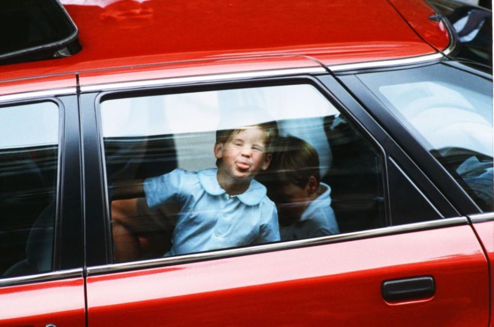 <p>A young Prince Harry sticks out his tongue and presses his face against the car window after visiting the Duchess of York and baby Princess Beatrice. <br></p>