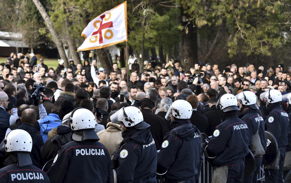 Police officers guard the parliament building in Podgorica, Montenegro, Thursday, Dec. 26, 2019, during a protest against a proposed law regarding religious communities and property. The Serbian Orthodox Church says the law will strip it of its property, including medieval monasteries and churches. The government has denied that. (AP Photo/Risto Bozovic)