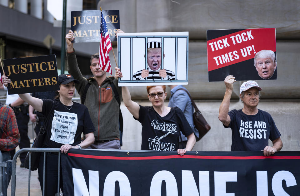 Protesters gather before former President Donald Trump arrives in a motorcade for a deposition in New York Thursday, April 13, 2023. (AP Photo/Craig Ruttle)