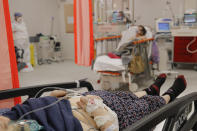 Patients lie on beds in the emergency room, turned into a CODIV-19 unit due the high number of cases, at the Bagdasar-Arseni hospital in Bucharest, Romania, Tuesday, Oct. 12, 2021. Romania reported on Tuesday nearly 17,000 new COVID-19 infections and 442 deaths, the highest number of coronavirus infections and deaths in a day since the pandemic started, as the nation's health care system struggles to cope with an acute surge of new cases.(AP Photo/Andreea Alexandru)