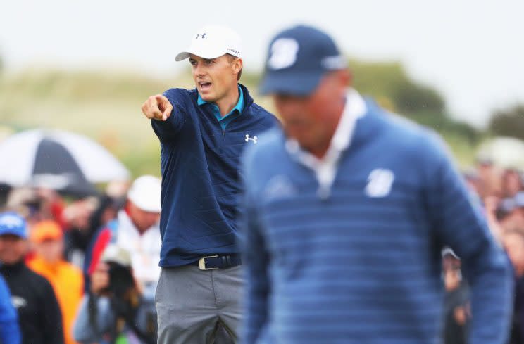 Jordan Spieth exults as Matt Kuchar walks past. (Getty)