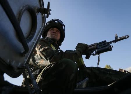 A Ukrainian paratrooper rides on an armored vehicle near Zhdanivka September 13, 2014. REUTERS/Gleb Garanich