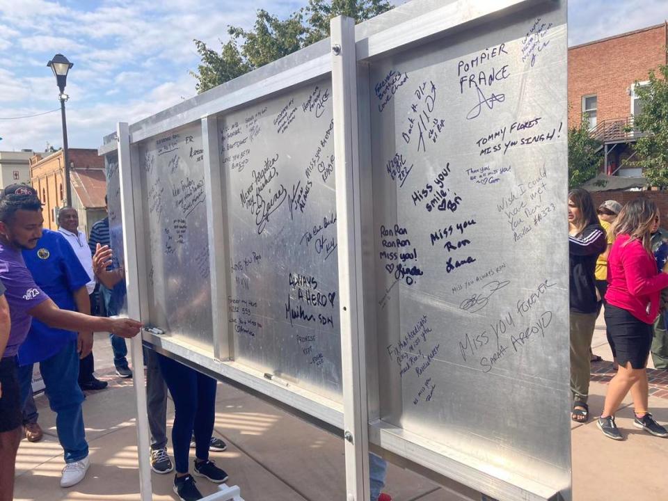 Ronil Singh’s brother Reggie signs the back of the sign proclaiming a stretch of Highway 33 in Newman as the Corporal Ronil Singh Memorial Highway. A clear coat will preserve the messages, the Newman Police Department said on Facebook.