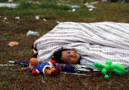 A child, part of a caravan of Central American migrants moving through Mexico toward the U.S. border, peeks from underneath a blanket after waking up at a sports field in Matias Romero, Mexico April 5, 2018. REUTERS/Henry Romero