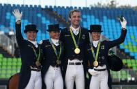 <p>(L-R) The German team of Isabell Werth, Dorothee Schneider, Sonke Rothenberger and Kristina Broring-Sprehe pose after winning the team gold during the final day of the Dressage Grand Prix event on Day 7 of the Rio 2016 Olympic Games held at the Olympic Deodora Equestrian Centre on August 12, 2016 in Rio de Janeiro, Brazil. (Photo by David Rogers/Getty Images) </p>