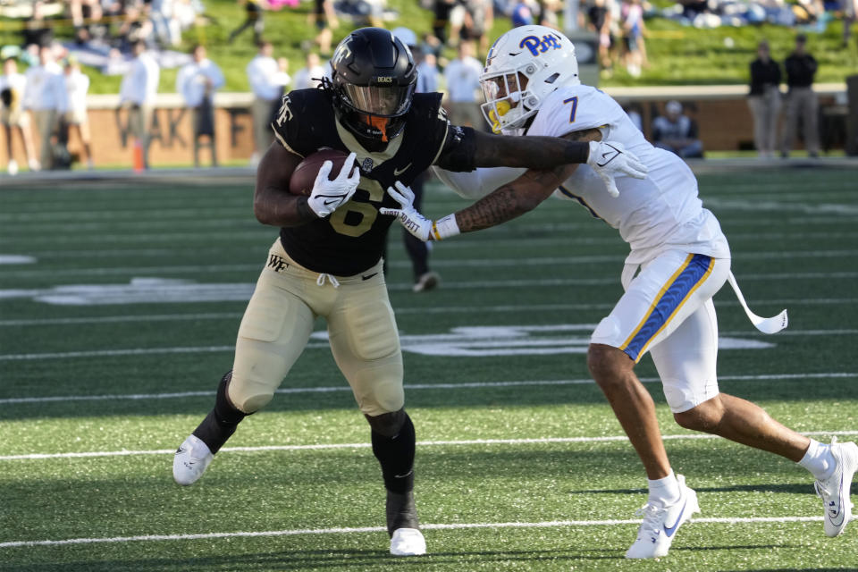 Wake Forest running back Justice Ellison (6) runs for a first down as Pittsburgh defensive back Javon McIntyre (7) defends during the first half of an NCAA college football game in Winston-Salem, N.C., Saturday, Oct. 21, 2023. (AP Photo/Chuck Burton)