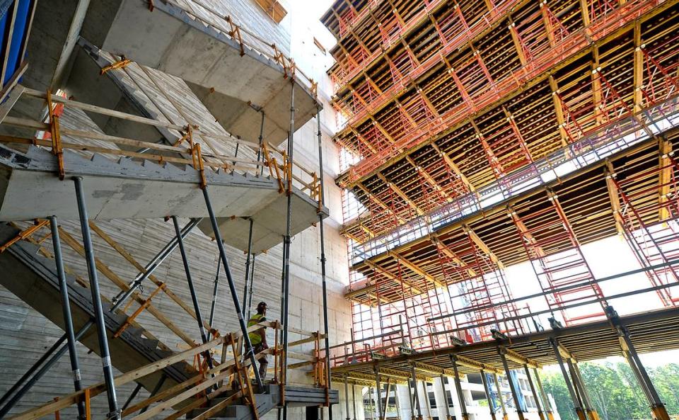 A construction worker, left, climbs a set of stairs in a lobby area of the 800,000-square-foot Centene Corp. East Coast headquarters at University City Research Park in Charlotte.