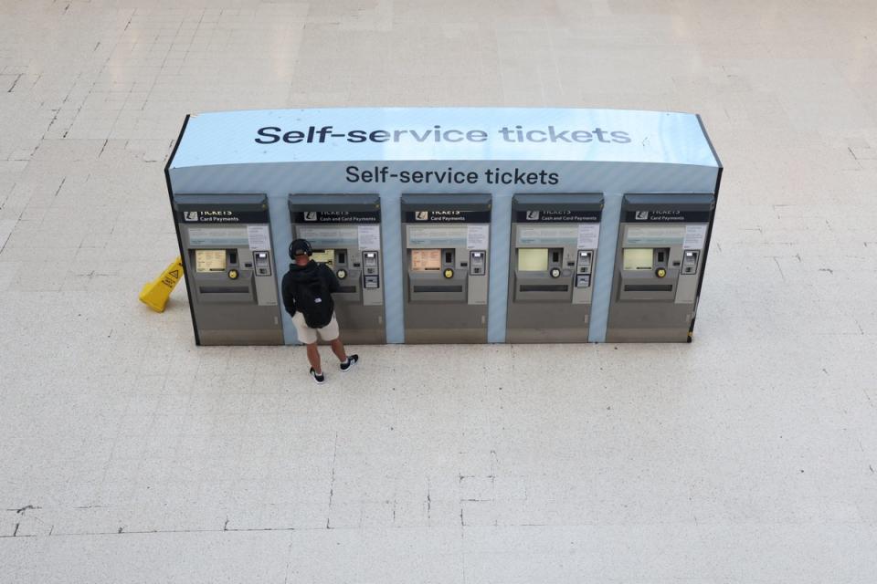 A passenger buys tickets from a self-service ticket machine at Waterloo station, London, (PA)