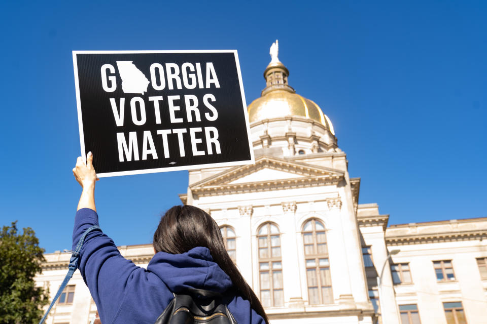 A demonstrator stands outside of the Georgia Capitol building in Atlanta on March 3, to oppose a measure that would dramatically limit access to voting throughout the state. (Photo: Megan Varner via Getty Images)