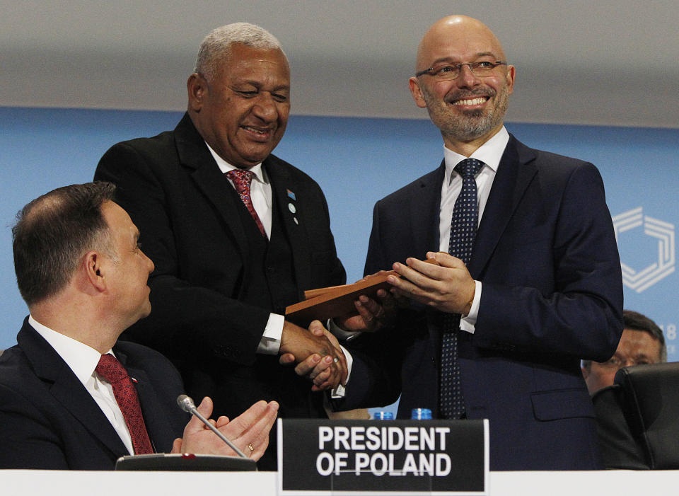 Prime Minister of Fiji and COP 23 President Frank Bainimarama talks with the President of COP 24 Michal Kurtyka, right, as Polish President Andrzej Duda, left, looks on during the opening of COP24 UN Climate Change Conference 2018 in Katowice, Poland, Monday, Dec. 3, 2018. (AP Photo/Czarek Sokolowski)