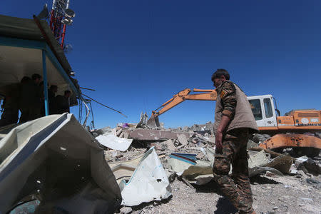 Members of the Kurdish People's Protection Units (YPG) inspect the damage at their headquarters after it was hit by Turkish airstrikes in Mount Karachok near Malikiya, Syria. REUTERS/ Rodi Said