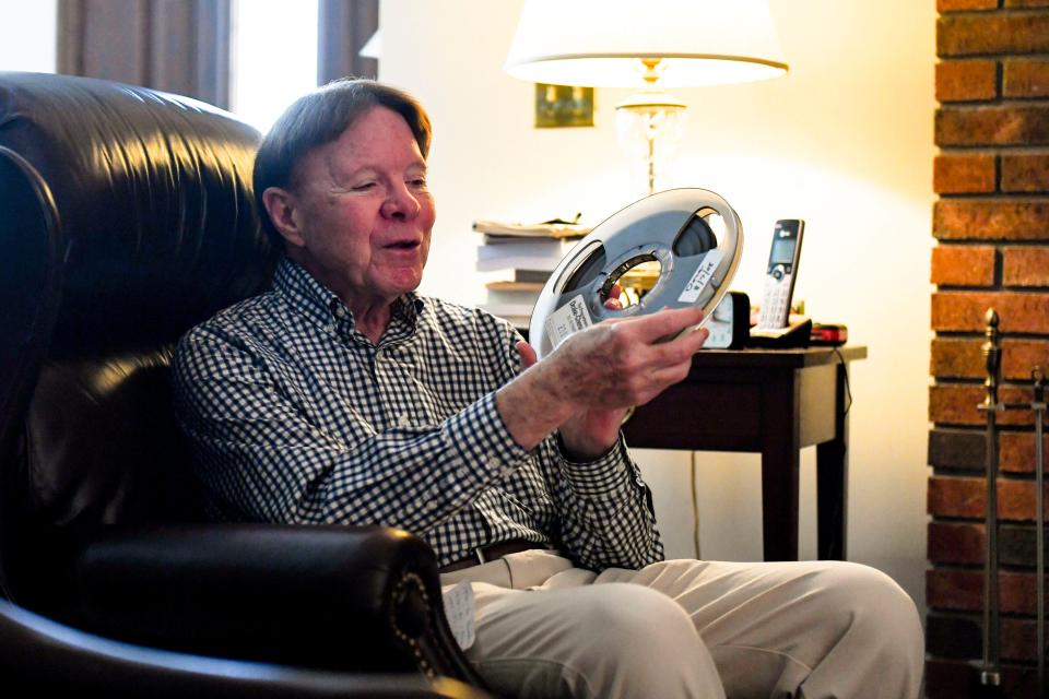 Lee Alexander, local radio host for 53 years, looks at a reel-to-reel, one of the many forms technology took to play music over the radio in his decades of experience as a host, in his home in Greenville, SC, on Monday, Oct. 30, 2023.