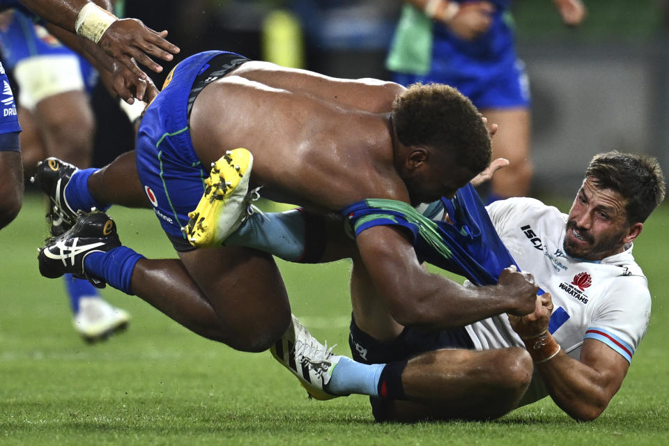 Jake Gordon of the Sydney, Australia-based Waratahs tackles Tevita Ikanivere of Fijian Drua in their Super Rugby Pacific match in Melbourne, Saturday, March 4, 2023. (Joel Carrett/AAP Image via AP)