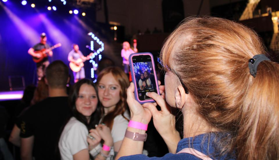 Loretta Mabry of Powhatan takes a picture of her daughter Carrie and friend Molly, on the left, at an Oliver Anthony concert at Longwood University in Farmville on October 28.