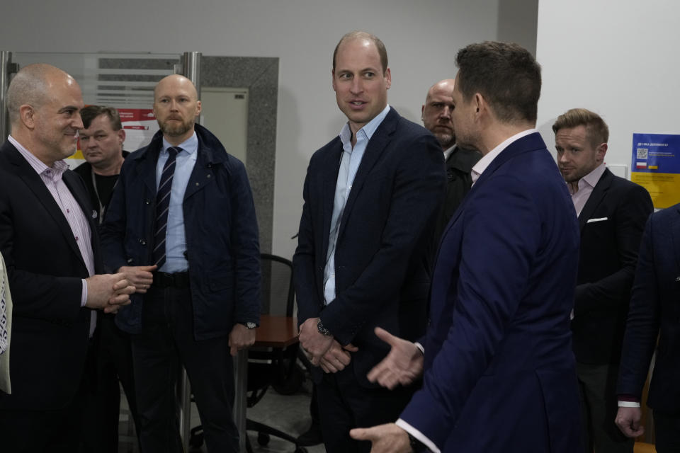 Britain's Prince William, center, talks to Mayor of Warsaw Rafal Trzaskowski, right, as they visit an accommodation centre, for Ukrainians who fled the war, in Warsaw, Poland, Wednesday, March 22, 2023. (AP Photo/Czarek Sokolowski)