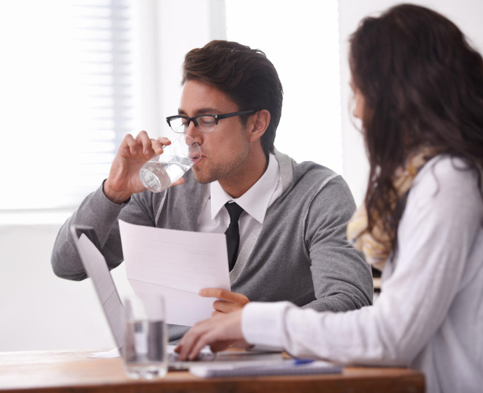 Pictured: Job interview with man drinking glass of water. Image: Getty