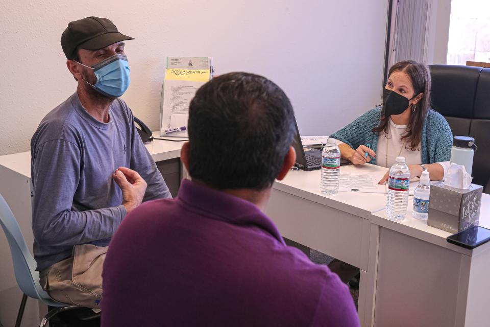 Volunteer attorney Kerry Van Dusen, right, and interpreter Noorullah Bakhtyar, left, work with an Afghan evacuee and help him apply for asylum at the American Gateways offices in North Austin, Texas on Feb. 19, 2022.