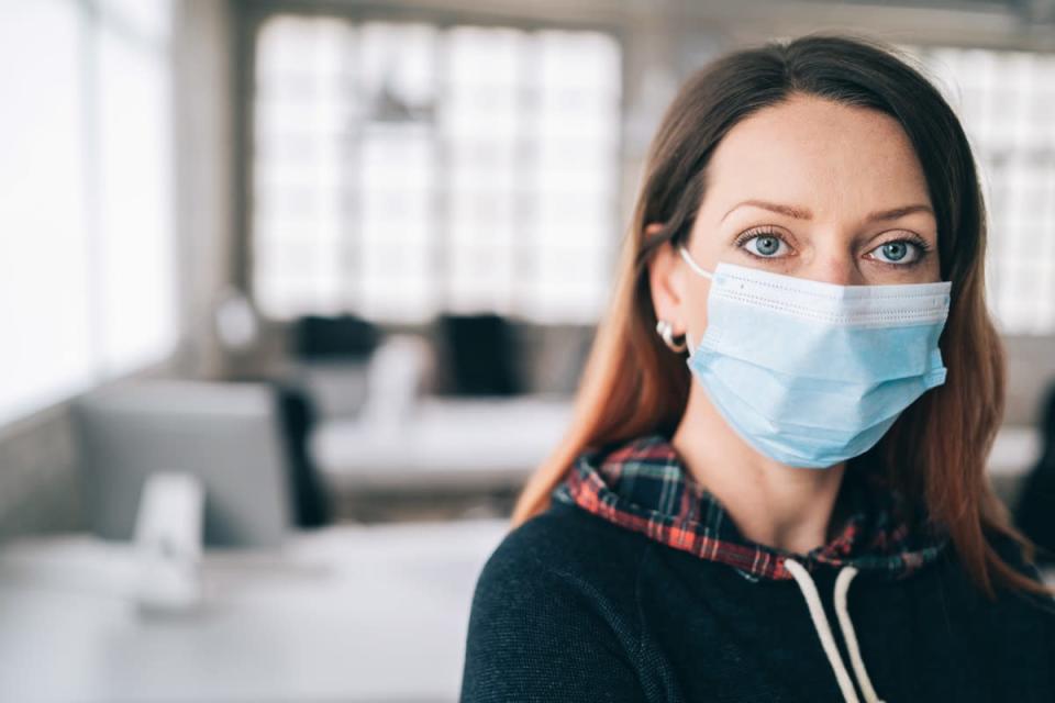 Woman wearing protective face mask in the office