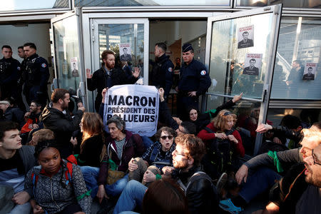 Environmental activists block the entrance of the Ministry of Ecology, Energy and Sustainable Development during a "civil disobedience action" to urge world leaders to act against climate change, in La Defense near Paris, France, April 19, 2019. The slogan reads " Macron, President of polluters". REUTERS/Benoit Tessier