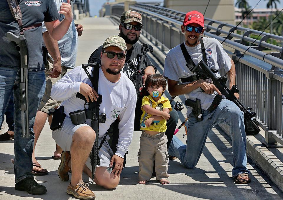 Members of the gun-rights group Florida Carry Lukas Garcia, from left, Ruben Espinosa, and Michael Taylor hold an assembly at the Royal Park Bridge on March 23, 2019. With them is Slade Espinosa, 2.