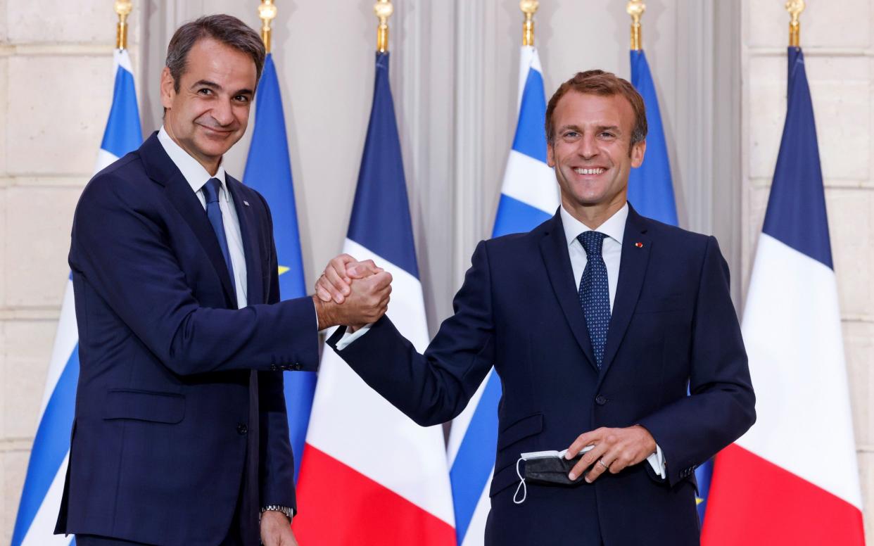 Greek prime minister Kyriakos Mitsotakis (L) shakes hands with French President Emmanuel Macron at the Elysee Palace - Shutterstock