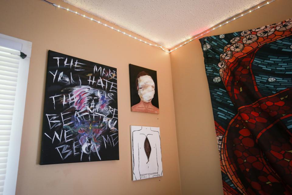 Paintings depicting gender dysphoria hang on Romeo's bedroom walls on Thursday, April 20, 2023.