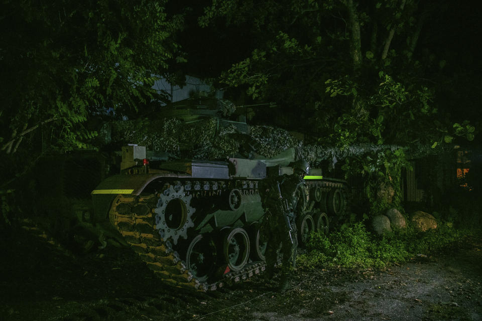 In this photo released by the Military News Agency, a soldier and tank prepare for the annual Han Kuang live-fire drills in Hualian, eastern Taiwan in the early hours of Tuesday, Sept. 14, 2021. (Military News Agency via AP)