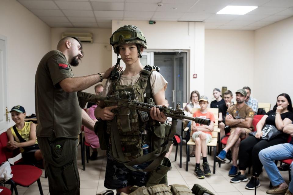 Military instructor checks the military equipment on a boy during lecture for civilians on July 12, 2023 in Zaporizhzhia, Ukraine. Military training instructor of non-governmental organization 